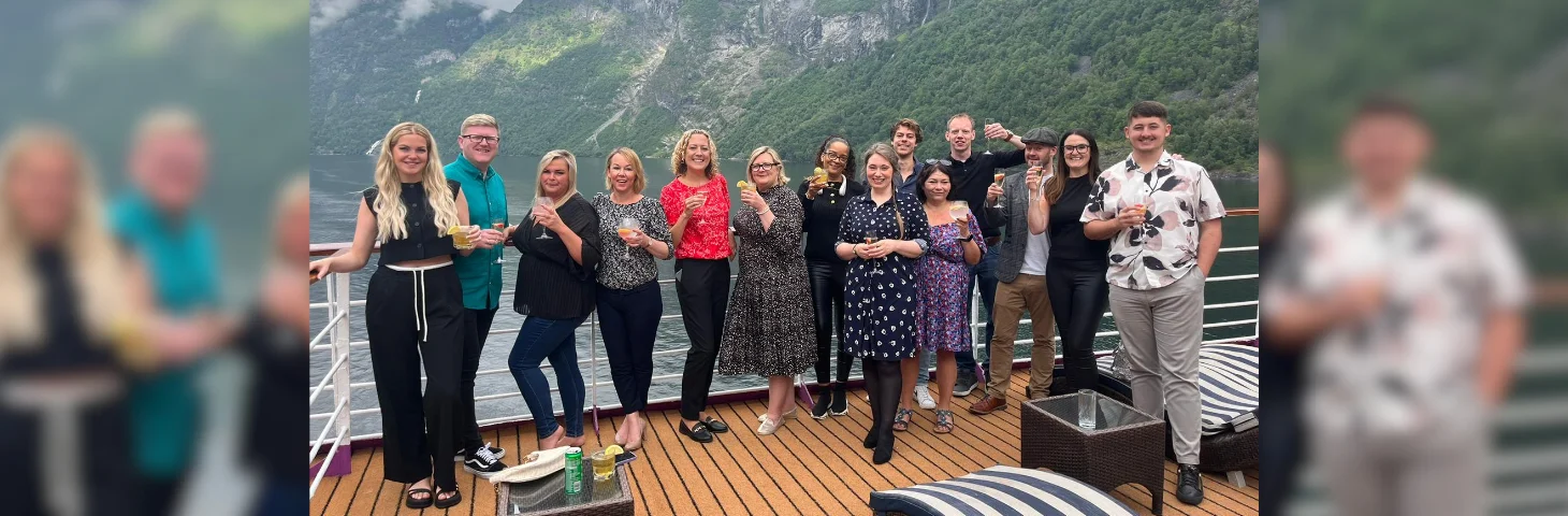 A group of travel agents on the deck of Ambassador Cruise Line's Ambience ship as it sails in the Norwegian fjordlands.