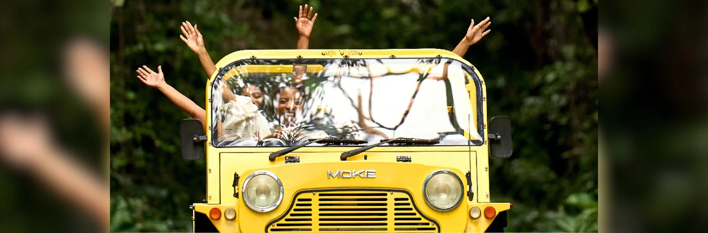 A group of travellers in a yellow MOKE jeep in Barbados.