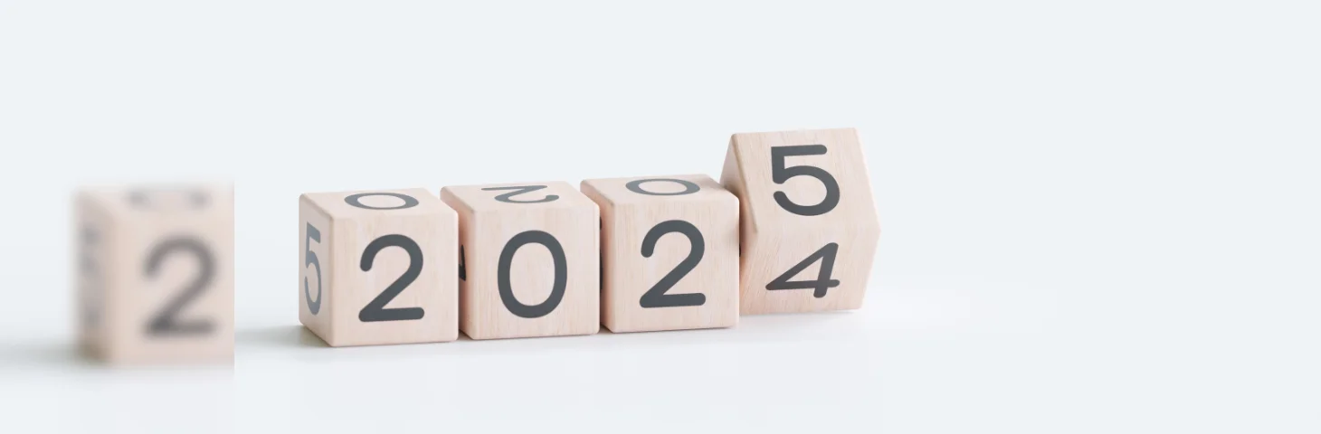 Wooden blocks displaying the numbers 2024. The final block is being turned to change the number to 2025.