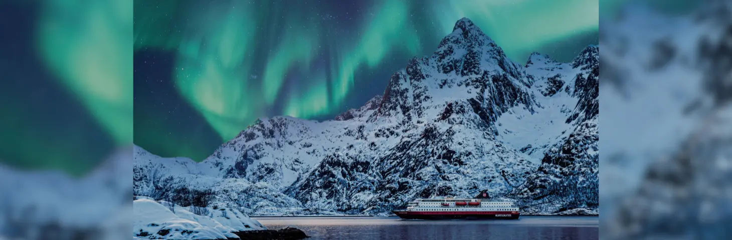 Image of a Hurtigruten vessel underneath the Northern Lights