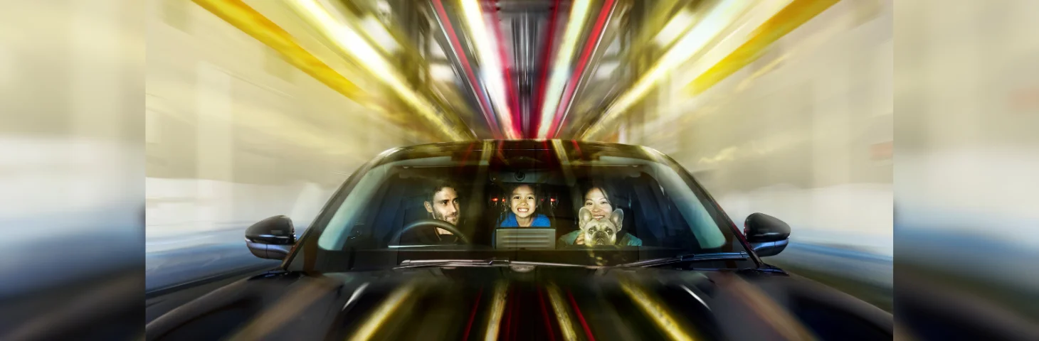 A family of three (two adults and one child) in a black car aboard the Channel Tunnel/LeShuttle.