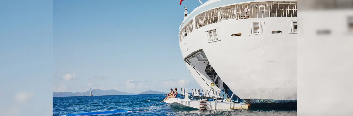 Image of two people sat on the dock at the back of a Windstar vessel