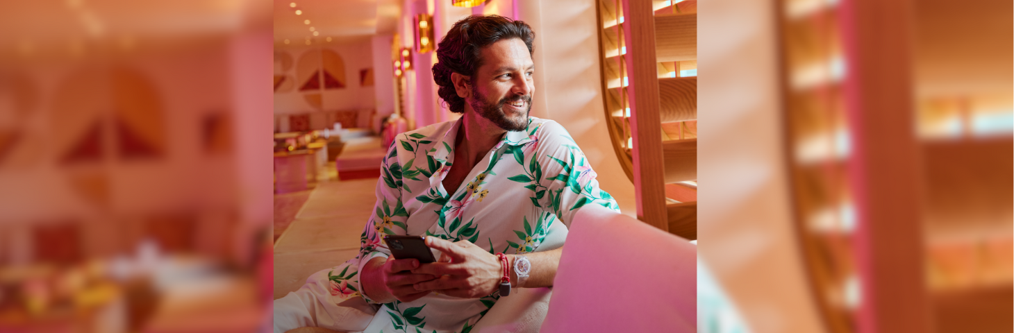 A person on their phone looking out of the window on a cruise ship